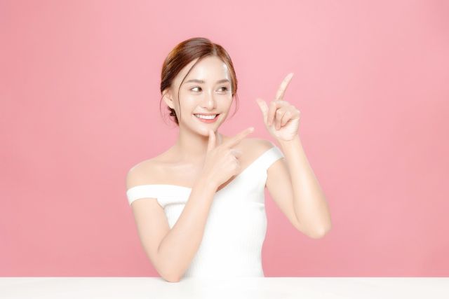 右を指さす女性