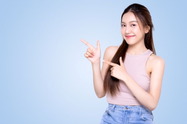 左を指さす女性