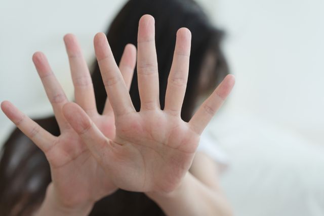 両手をこちらに向けて何かにおびえる女性